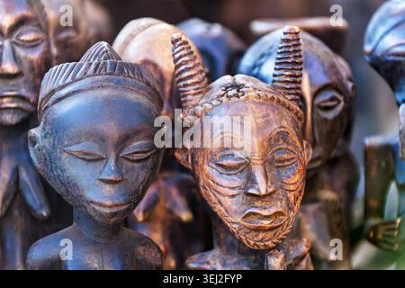 Sculptures en bois du peuple Baule de Côte d'Ivoire, représentant une figure d'esprit cornée avec des motifs de scarification faciale au premier plan et styl Banque D'Images