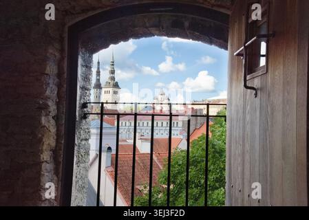 Une vue panoramique à travers une vieille fenêtre sur les toits de la vieille ville de Tallinn en Estonie, y compris l'église Nicholas et la cathédrale Alexandre Nevsky Banque D'Images