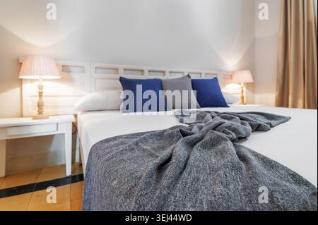 Intérieur moderne de la chambre avec lit confortable et éclairage chaleureux Banque D'Images
