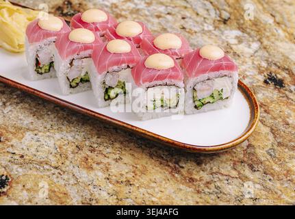 Gastronomie, Un plateau magnifiquement agencé présente des rouleaux de sushi vibrants recouverts de délicates tranches de poisson Banque D'Images