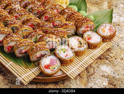 Nourriture, Un grand plateau présente un assortiment de rouleaux de sushi, avec des textures croustillantes et des garnitures vibrantes. Les rouleaux sont magnifiquement disposés avec g Banque D'Images