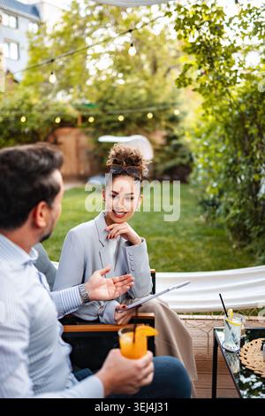 Professionnels discutant du travail dans un patio de café en plein air Banque D'Images