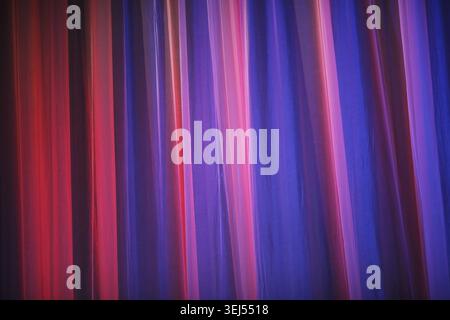 Rideau de théâtre violet. Fond violet abstrait. Gros plan d'un rideau de théâtre. Rideaux théâtre éclairé par une lumière vive de projecteurs Banque D'Images