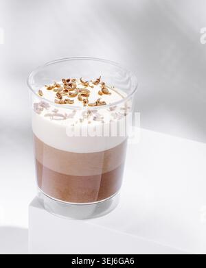 Nourriture, ce dessert dispose d'une belle superposition de chocolat et de crème, surmontée d'une pincée de morceaux croquants. Parfaitement servi dans un verre élégant Banque D'Images