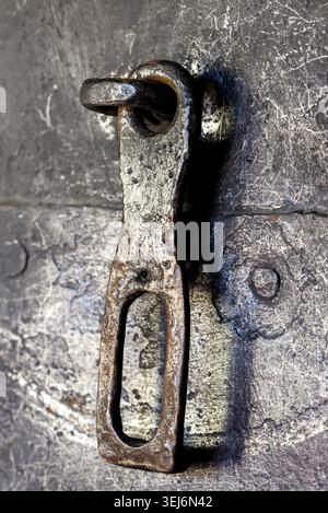 Photo macro d'un vieux loquet en métal corrodé sur une surface de porte endommagée, symbolisant la durabilité Banque D'Images