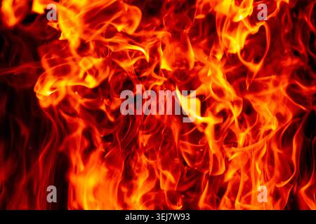 Texture de flamme et lueur ardente. Étincelles de flamme flottant dans l'espace noir. Effet abstrait brûlé à la flamme. Motif flammes superposées. Banque D'Images