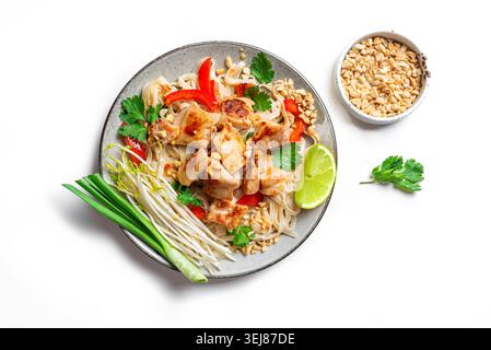 Nouilles thaïlandaises authentiques au poulet nappées de cacahuètes écrasées, de germes de haricots, de coriandre et de citron vert. Repas thaïlandais, nouilles de poulet sautées isolées o Banque D'Images