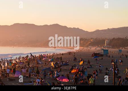 Les foules se rassemblent le long de la plage de Santa Monica au coucher du soleil tandis que les visiteurs profitent du temps chaud le long de la côte pacifique à Santa Monica Banque D'Images