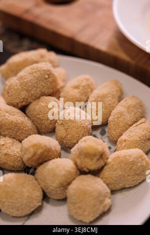 Croquettes boulées maison sur assiette blanche prête à frire, recette espagnole traditionnelle. Banque D'Images