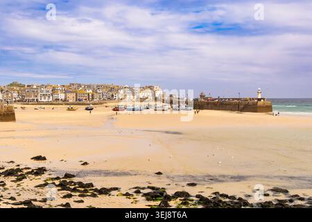 Vue sur la plage de sable jusqu'au port et à la jetée de Smeaton à marée basse. St Ives, Cornouailles, Angleterre, Royaume-Uni, Grande-Bretagne Banque D'Images