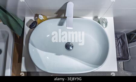 Vue de dessus du lavabo moderne avec articles de toilette et décoration intérieure minimaliste Banque D'Images