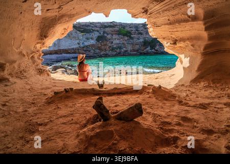 Vue panoramique sur les eaux turquoises encadrées par une grotte naturelle le long de la côte de Formentera à Cala en Baster. Banque D'Images