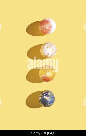 Affichage créatif de quatre oeufs de pâques texturés colorés jetant des ombres sur fond jaune Banque D'Images