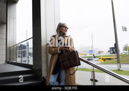 une avocate de 50 ans attend un client pour une réunion près du centre d'affaires Banque D'Images