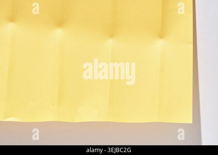 Texture de papier plié jaune avec des ombres sur un fond clair pour un design créatif et une inspiration artistique Banque D'Images