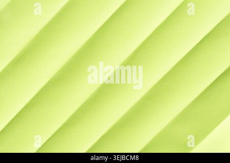 Tissu texturé vert citron diagonal abstrait avec des ombres douces dans une surface répétitive à motifs Banque D'Images