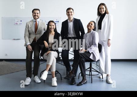 Portrait d'un groupe réussi de gens d'affaires au bureau moderne regardant la caméra. Portrait des hommes d'affaires heureux et des femmes d'affaires satisfaites debout Banque D'Images