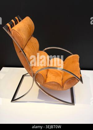 Profil latéral du fauteuil moderne par le designer norvégien Sverre Fehn avec coussins en cuir marron orange et cadre courbé en métal chromé Banque D'Images