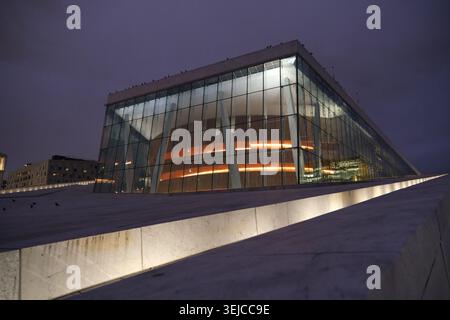 Oslo, Norvège-Nov.25th 2025 : vue ascendante basse de l'Opéra d'Oslo la nuit, lignes de rampe de toit en marbre et façade vitrée illuminée Banque D'Images
