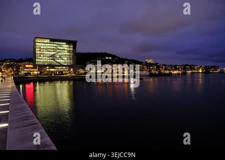 Oslo, Norvège-Nov.25th 2025 : vue large lointaine du musée Munch et du front de mer à Oslo la nuit, lumières modernes du bâtiment et reflets de l'eau Banque D'Images