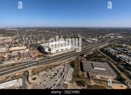 Vue aérienne montrant le stade Alamodome à côté d'une autoroute avec des parkings et une expansion urbaine sous un ciel bleu à San Antonio, Texas, États-Unis Banque D'Images