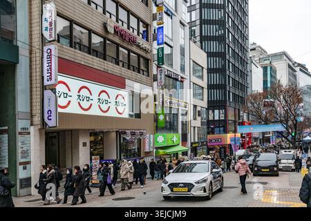 Séoul, Corée du Sud - 26 décembre 2025 : piétons occupés et circulation devant les panneaux colorés de la rue Myeongdong Banque D'Images