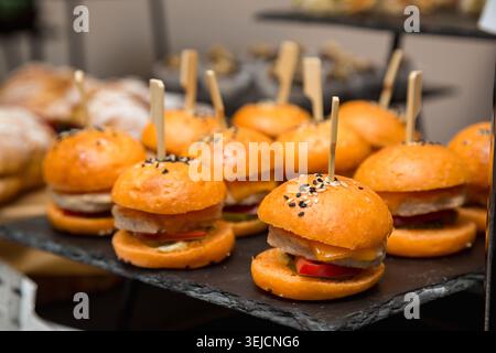 Gros plan sur les mini hamburgers et les cheeseburgers Sliders avec choix de bambou sur le présentoir de restauration Banque D'Images
