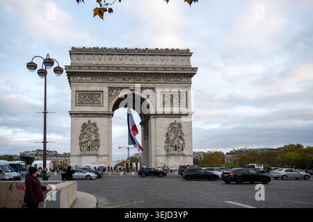 Paris, France - 8 novembre 24 : vue de face de l'Arc de Triomphe avec le drapeau tricolore français et la circulation sur la place Charles de Gaulle à Paris, France. Banque D'Images