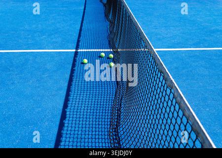 Fond d'équipement sportif avec trois balles jaunes sur un court de tennis bleu Banque D'Images