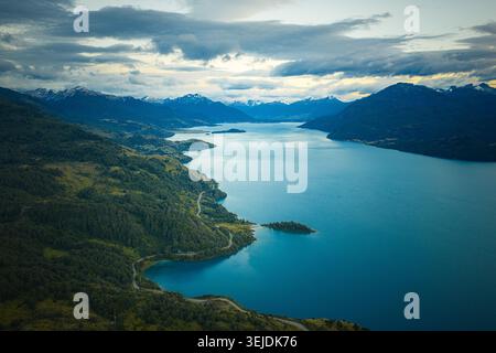 Route sinueuse à côté d'un vaste lac bleu de Patagonie Banque D'Images