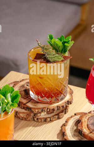 Cocktail artisanal de couleur ambre avec garniture d'herbes fraîches Banque D'Images