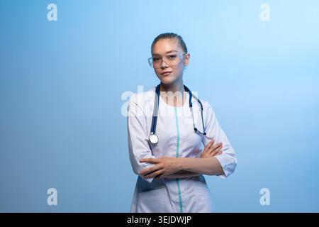 Jeune femme médecin portant un uniforme médical et des lunettes de sécurité Banque D'Images