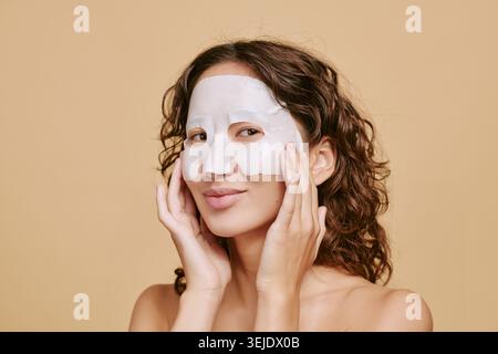 Portrait de femme asiatique adulte appliquant le masque de feuille pour les soins de la peau Banque D'Images