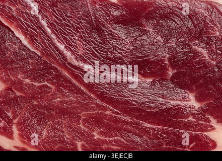 Gros plan détaillé de la texture de viande rouge crue fraîche avec marbrure grasse blanche. Bœuf ou steak de haute qualité pour une utilisation culinaire Banque D'Images
