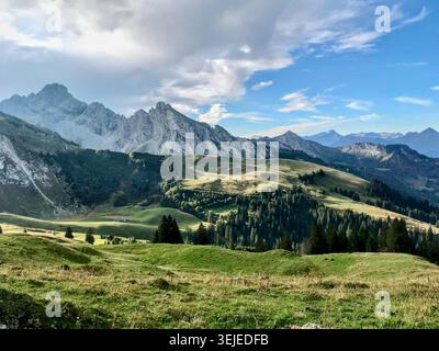 Paysage alpin spectaculaire avec des sommets enneigés et des prairies ensoleillées à Zweisimmen Suisse Banque D'Images