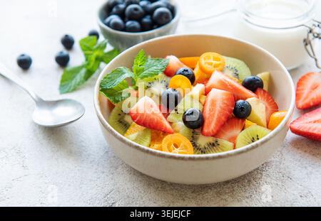 Salade de fruits frais saine dans un bol sur fond de bois Banque D'Images