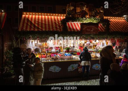 Nuremburg, Allemagne - 28 novembre 24 : étal de confiserie vendant des bonbons, des noix et des confiseries sous un toit rayé au marché de Noël de Nuremberg à Nurem Banque D'Images