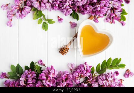 Miel aux fleurs d'acacia sur fond de bois Banque D'Images