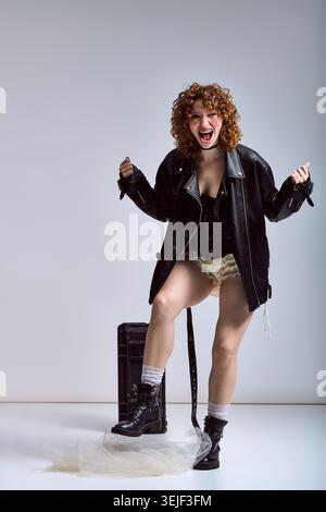 Femme confiante à la mode avant-gardiste pose avec excitation, mettant en valeur son style et sa personnalité uniques. Banque D'Images