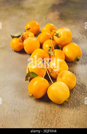Petites pommes jaunes, variété chinoise, dispersées sur la table, vue de dessus, pas de gens, Banque D'Images