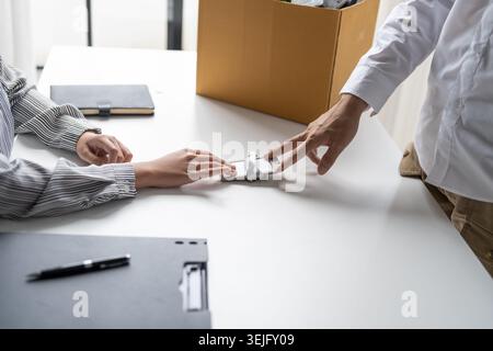 Homme d'affaires envoyant une lettre de démission au patron et tenant des choses démissionnent déprimer ou portant boîte en carton par bureau dans le bureau Banque D'Images