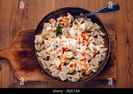 Boulettes turques traditionnelles servies avec yaourt et sauce épicée sur une assiette décorative verte Banque D'Images