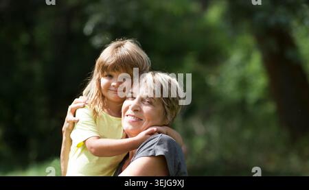 Grand-mère avec petite-fille souriante dans un parc Banque D'Images