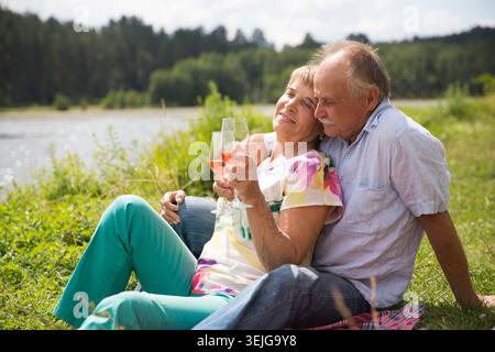 Charmant couple de personnes âgées au lac ayant un pique-nique Banque D'Images