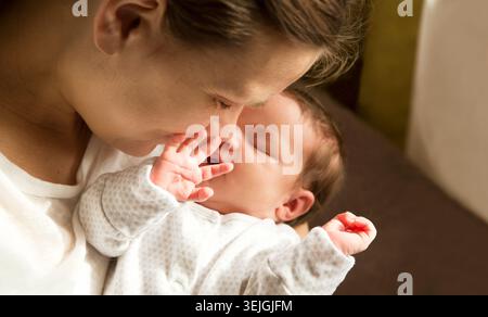 Concept de maternité. Parentalité. allaitement maternel. bébés sommeil sain. maman tient un petit bébé endormi à la maison. Joyeux baisers et Banque D'Images
