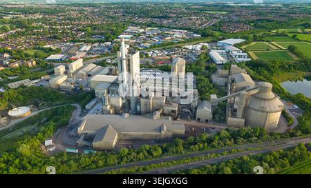Vue aérienne de la Rugby Cement Plant avec de hautes cheminées et des structures industrielles entourées d'une végétation luxuriante à Rugby, Angleterre, Royaume-Uni. Banque D'Images