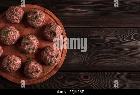 Boulettes de viande crues, avec micro-verdure, sur une planche à découper, faites maison, rustique, pas de personnes, Banque D'Images
