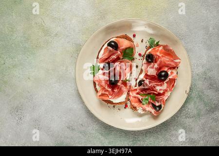 Sandwich au fromage à la crème, prosciutto aux olives , petit déjeuner, Banque D'Images