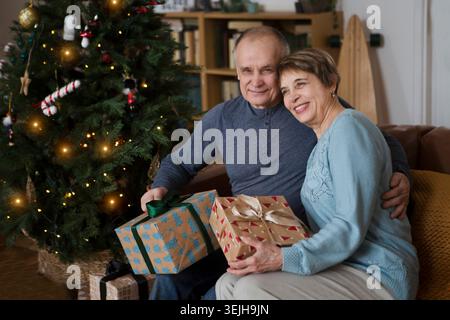 Grands-parents avec des cadeaux de Noël et célébrer les vacances à la maison au moment de Noël. Banque D'Images