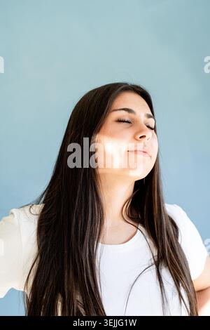 Portrait de femme brune avec reflet de prisme lumineux sur son visage Banque D'Images